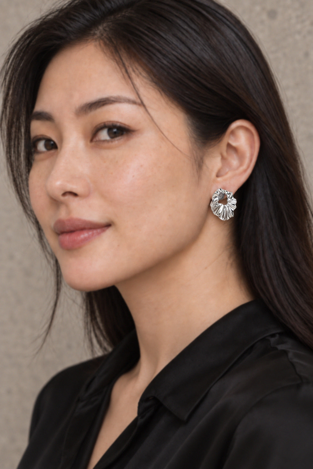 Sculptural pleated hoop earrings modeled
