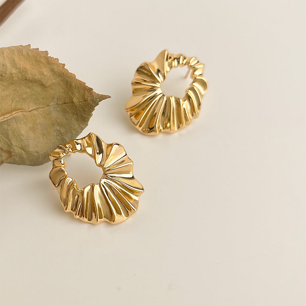 Gold pleated hoop earrings detail